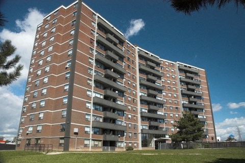 an apartment building on a sunny day with a blue sky